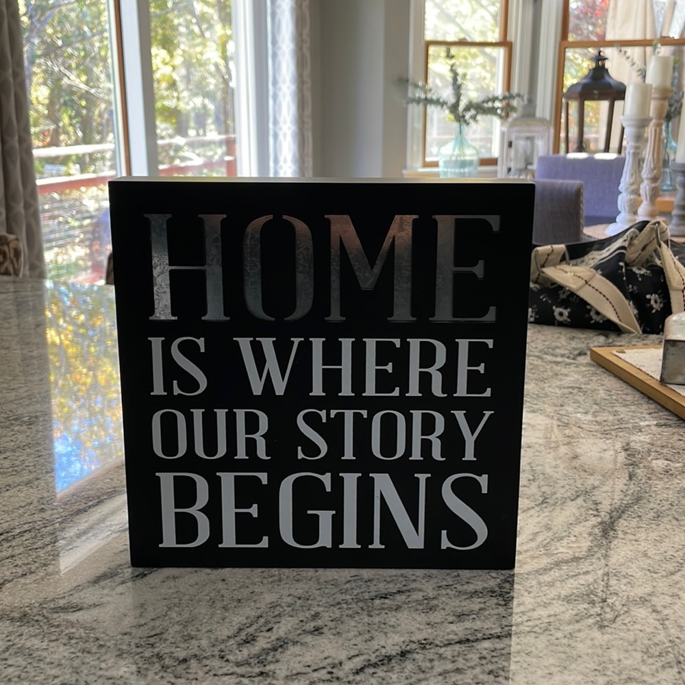 "home is where our story begins" sign